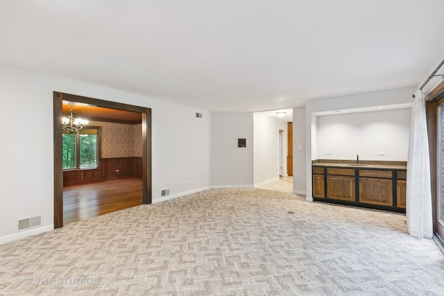 interior space with an inviting chandelier, sink, and wooden walls