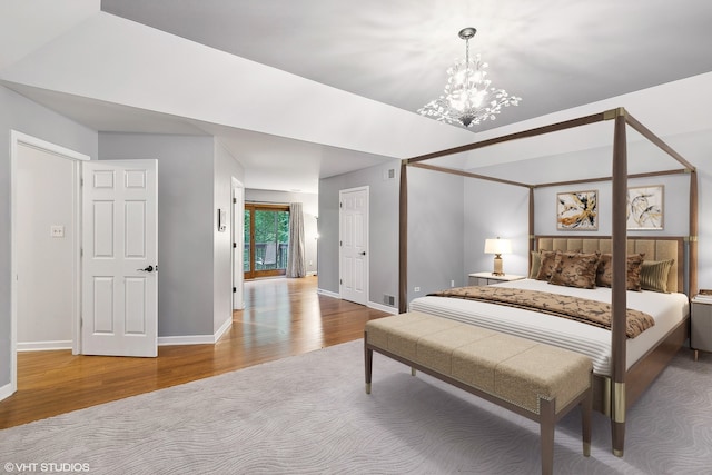 bedroom with wood-type flooring and a chandelier