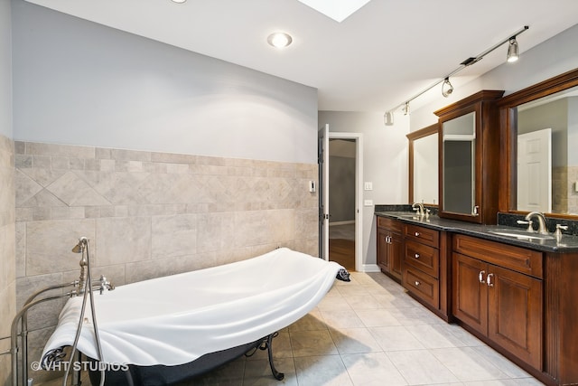 bathroom featuring vanity, tile walls, tile patterned floors, and a washtub