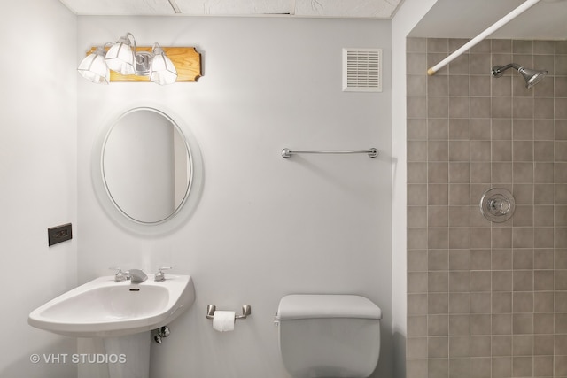 bathroom featuring toilet and tiled shower