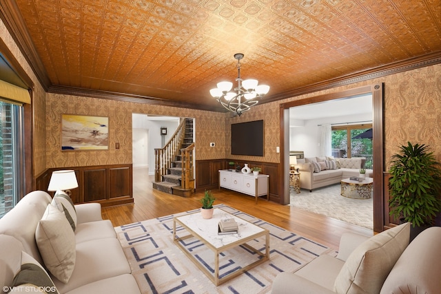 living room featuring crown molding, light wood-type flooring, and wooden walls