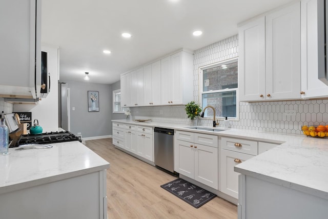 kitchen featuring white cabinetry, dishwasher, sink, stove, and light stone counters