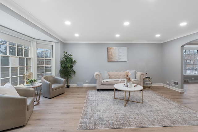 living room featuring crown molding and light wood-type flooring