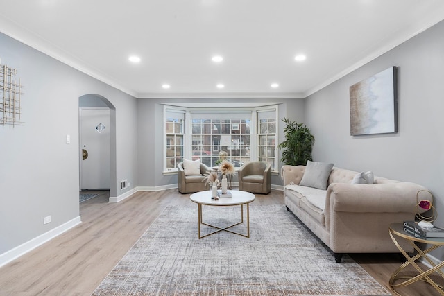 living room with crown molding and light wood-type flooring