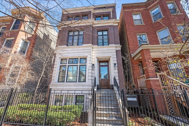 view of front of house with a fenced front yard and brick siding