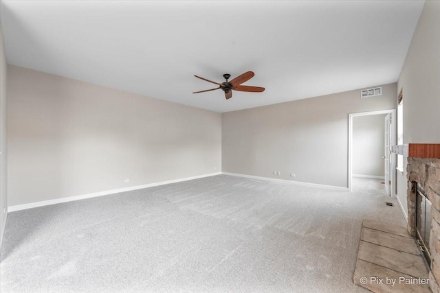 unfurnished living room with a fireplace, ceiling fan, and light carpet