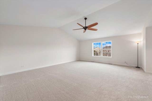 spare room with ceiling fan, light carpet, and lofted ceiling