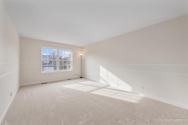 unfurnished room featuring light colored carpet