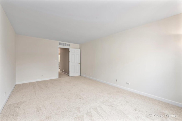 unfurnished room featuring light colored carpet