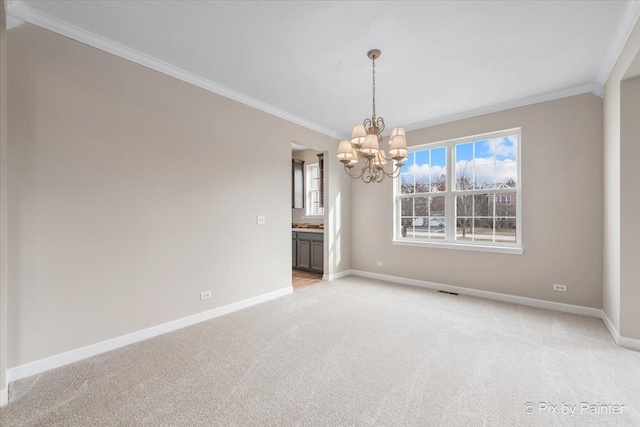 carpeted empty room with a healthy amount of sunlight, crown molding, and a chandelier