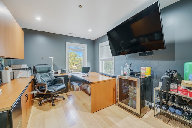 home office with light hardwood / wood-style flooring