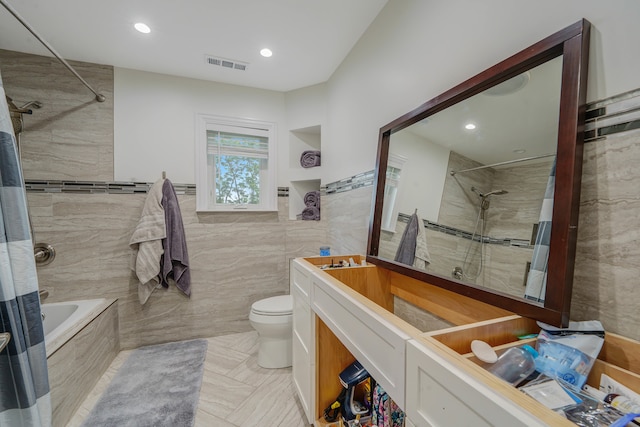 full bathroom featuring vanity, tiled shower / bath, tile walls, and toilet