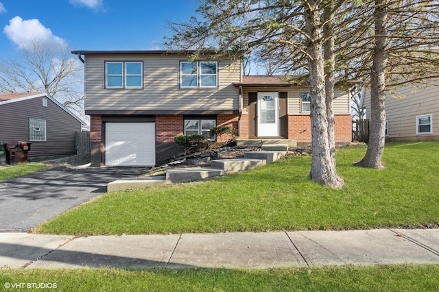 split level home with a front yard, brick siding, an attached garage, and driveway