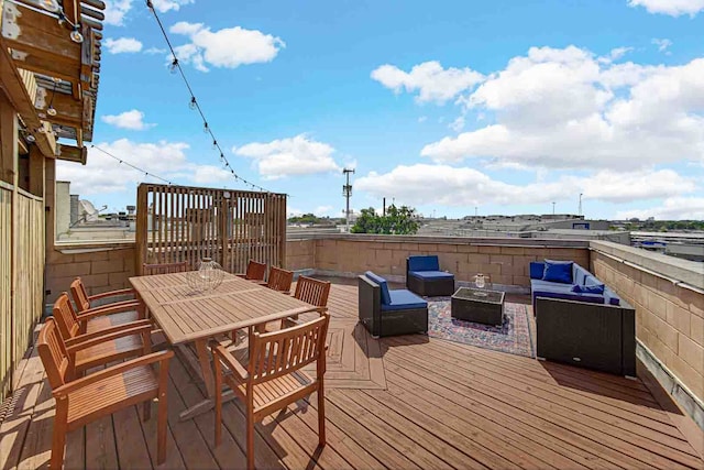 deck featuring an outdoor living space with a fire pit