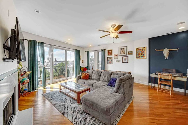 living room featuring ceiling fan and light hardwood / wood-style floors