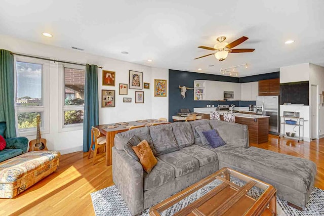 living room featuring light wood-type flooring and ceiling fan