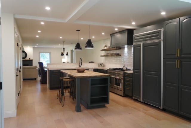 kitchen with a kitchen island, backsplash, high quality appliances, a kitchen bar, and light wood-type flooring