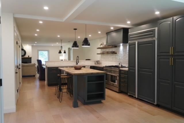 kitchen with a breakfast bar, open shelves, a peninsula, high quality appliances, and tasteful backsplash