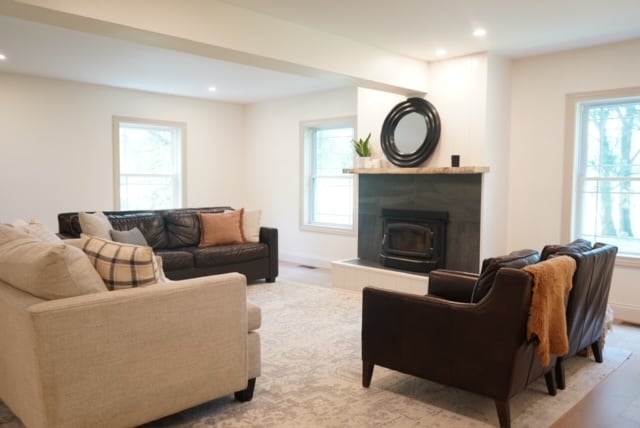 living room featuring hardwood / wood-style floors, a tiled fireplace, and a healthy amount of sunlight