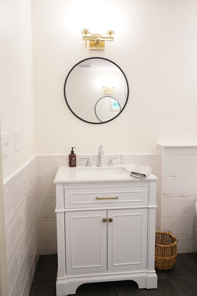 bathroom with tile walls, tile patterned flooring, and vanity