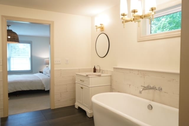 bathroom with plenty of natural light, a bathtub, tile walls, and vanity