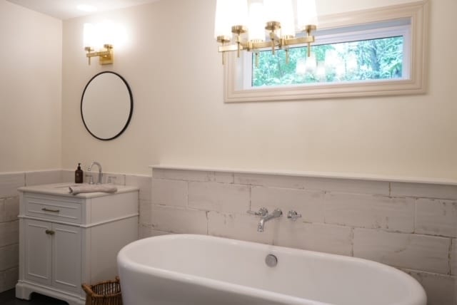 bathroom with a tub to relax in and vanity