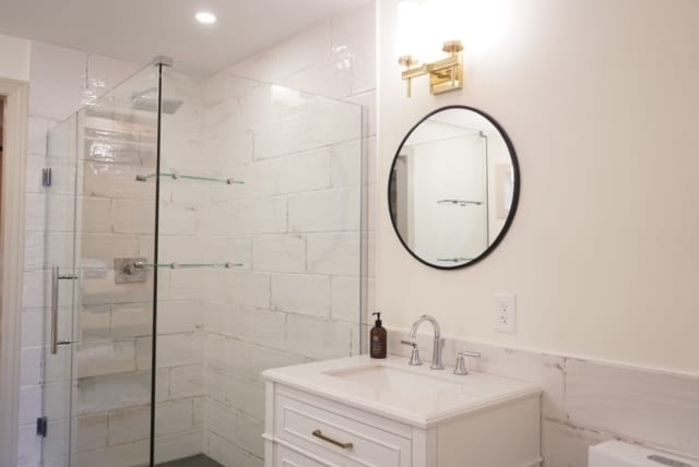 bathroom featuring vanity and a shower with door