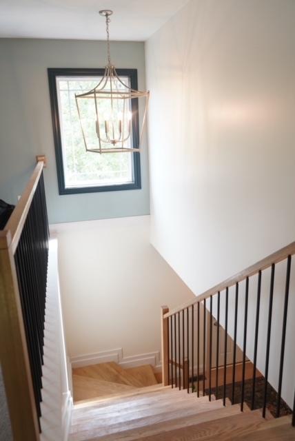 stairs featuring hardwood / wood-style floors and a notable chandelier