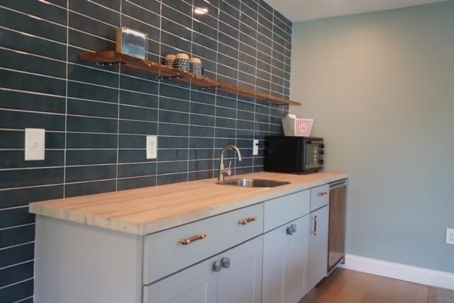 kitchen with wooden counters, backsplash, sink, and dark wood-type flooring