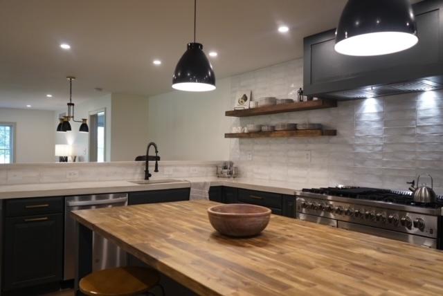 kitchen featuring pendant lighting, backsplash, butcher block countertops, sink, and appliances with stainless steel finishes