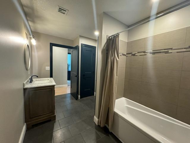 bathroom featuring tile patterned flooring, shower / bath combination with curtain, and vanity