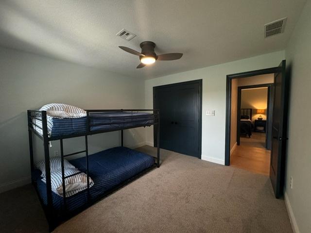 bedroom with ceiling fan, a textured ceiling, and carpet floors