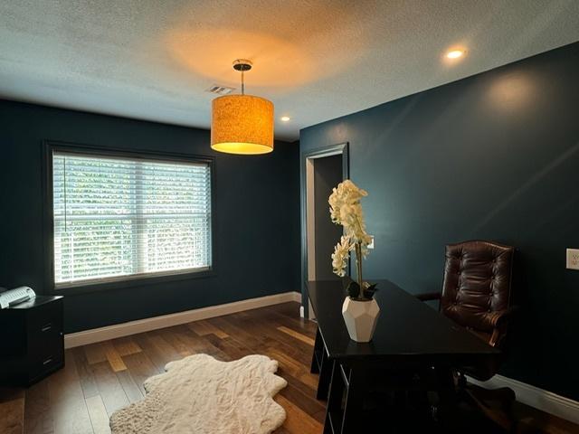 office featuring a textured ceiling and dark hardwood / wood-style flooring