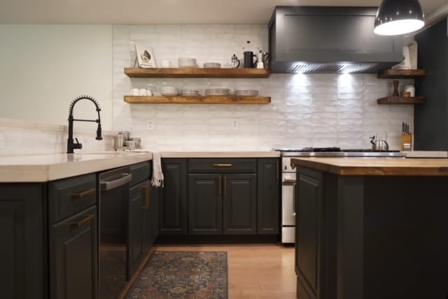 interior space featuring light wood-type flooring, appliances with stainless steel finishes, custom range hood, and backsplash