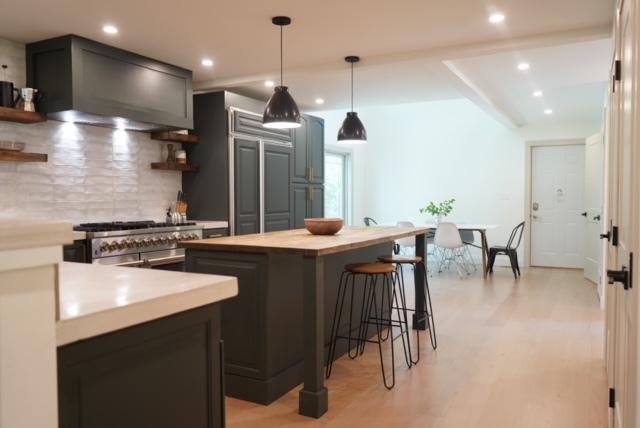 bar featuring light wood-type flooring, tasteful backsplash, gray cabinets, and premium range hood