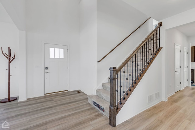 foyer featuring light wood-type flooring and a high ceiling