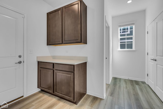 interior space with light wood-type flooring and dark brown cabinetry