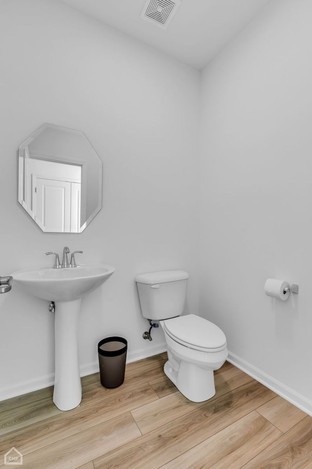 bathroom with toilet and hardwood / wood-style floors