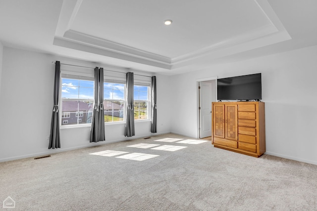 unfurnished bedroom with a tray ceiling and light carpet