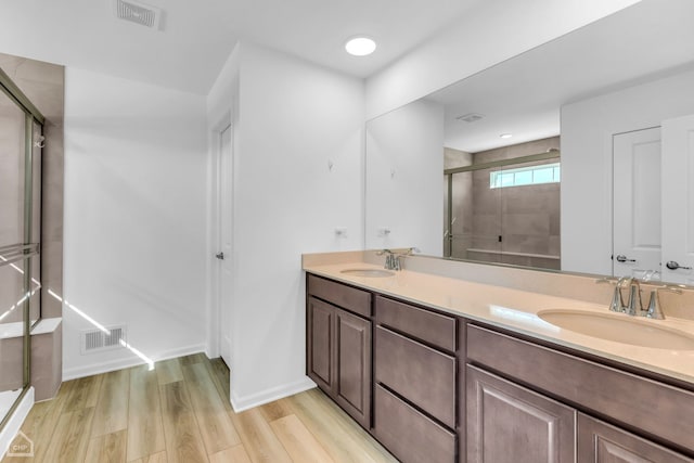 bathroom with vanity, hardwood / wood-style flooring, and walk in shower