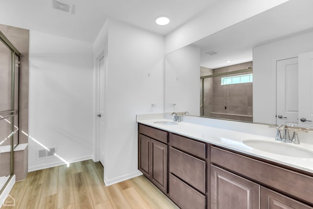 bathroom featuring vanity, wood-type flooring, and walk in shower