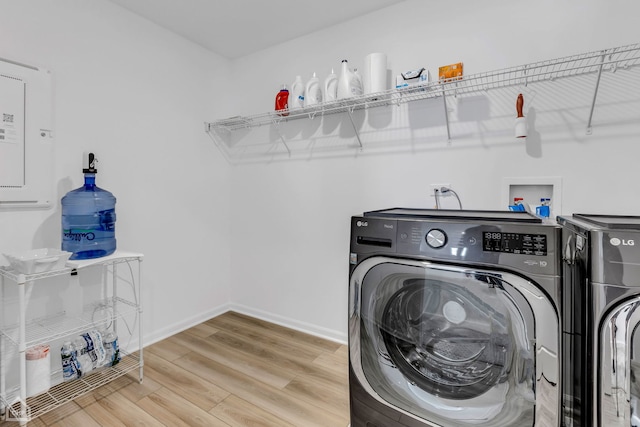 laundry room featuring separate washer and dryer and light hardwood / wood-style flooring