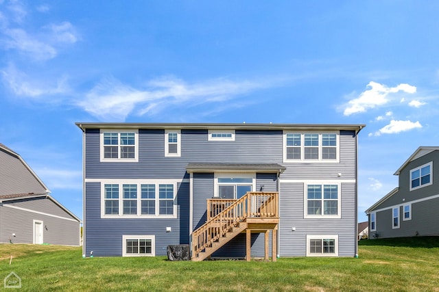 back of property featuring a wooden deck and a lawn