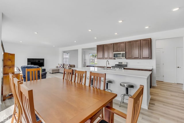 dining space with light wood-type flooring and sink