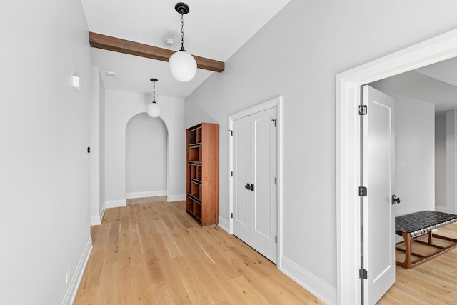 hallway with vaulted ceiling with beams and light hardwood / wood-style flooring