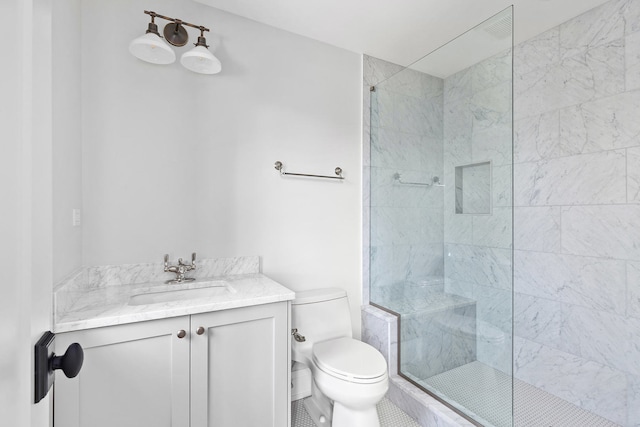 bathroom featuring tiled shower, tile patterned flooring, toilet, and vanity