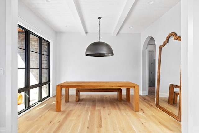 dining room with beam ceiling and light hardwood / wood-style flooring