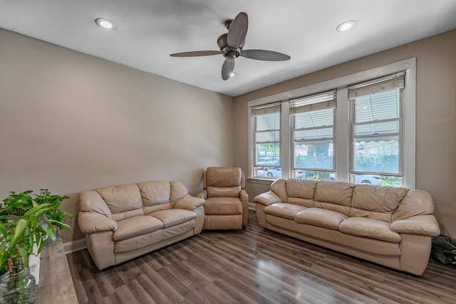 living room featuring dark wood-type flooring and ceiling fan