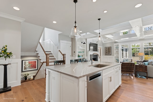 kitchen featuring dishwasher, light hardwood / wood-style flooring, white cabinetry, sink, and a kitchen island with sink