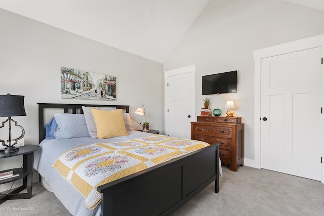 carpeted bedroom with high vaulted ceiling